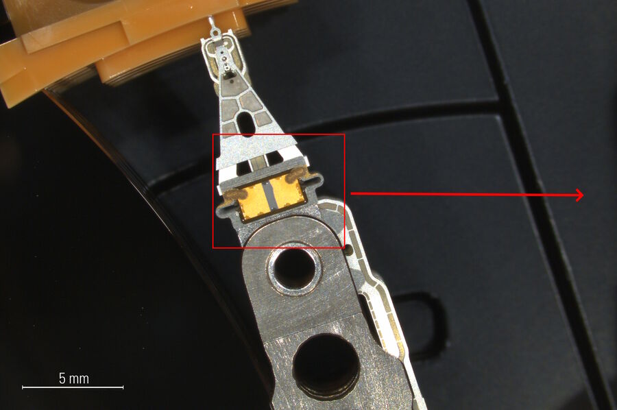 Image of a hard drive read-write head and actuator arm at lower magnification.