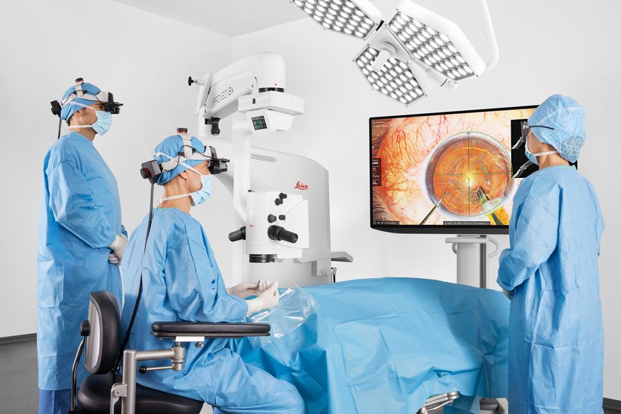 Surgical team collaborating during a cataract surgery using MyVeo 3D surgical headsets, with one team member viewing the procedure with 3D glasses and 55” monitor
