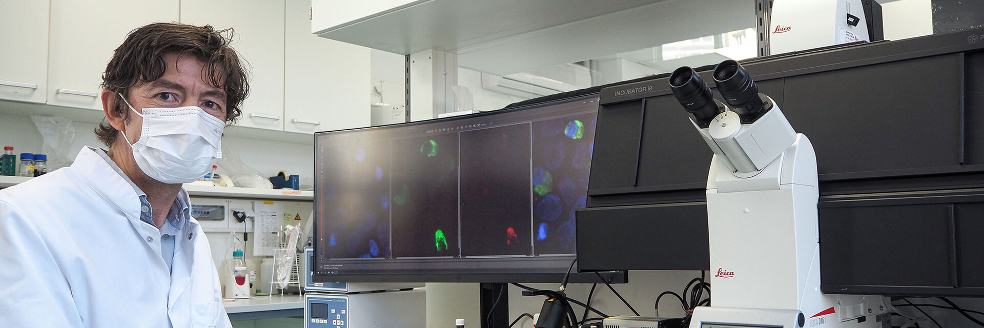 Der Direktor des Instituts für Virologie auf dem Campus Charité Mitte, Prof. Dr. Christian Drosten, am Laborarbeitsplatz mit dem THUNDER Imager 3D Live Cell von Leica Microsystems.