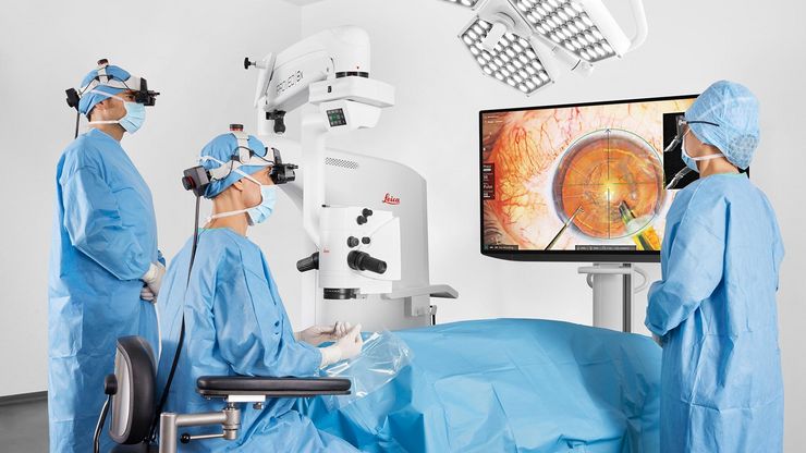 Surgical team collaborating during a cataract surgery using MyVeo 3D surgical headsets, with one team member viewing the procedure on a 3D monitor