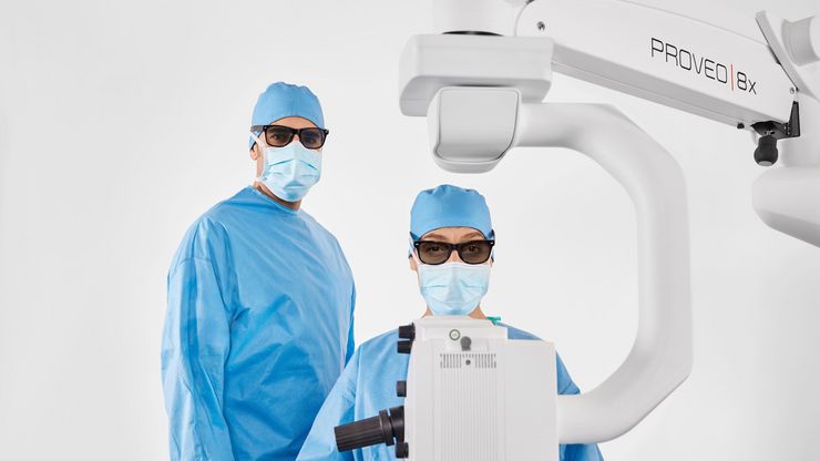 Proveo 8x 3D digital microscope used in ophthalmic surgery, illustrating heads‑up visualization and clinical collaboration.